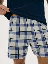 Pijama de hombre compuesto por una remera azul marino de cuello V y un short a cuadros en tonos azul, blanco y gris.