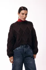 Sweater de tejido de punto grueso con diseño de rombos en relieve, cuello redondo y mangas largas amplias. Presenta una silueta relajada y holgada.