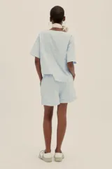 Conjunto celeste a rayas verticales, compuesto por un top corto de mangas cortas y un short de tiro alto con pinzas.