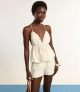 Short de cambraia color blanco, de cintura alta con elástico y bordados en la parte delantera. Tiene forro interior.