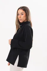 Camisa de manga larga color negro, de cuello redondo con frunces, abotonada en el frente y puños abiertos con tajo.