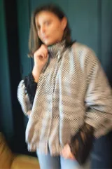 Campera tipo bomber oversize de paño italiano con estampado de espiga en blanco y negro. Presenta cuello alto, cierre frontal con botones metálicos y mangas estilo murciélago.