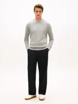 Sweater gris de punto texturizado, de cuello redondo, con detalles de ribetes en punto canalé en puños, cuello y bajo. Presenta un pequeño logo bordado en el pecho.