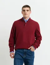 Sweater de punto color tostado, con cuello alto y cierre frontal parcial con botones. Diseño de manga larga con puños y ruedo acanalados.