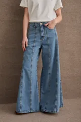 Jean de tiro alto con corte wide leg y diseño de costuras verticales a contratono en el frente. Presenta cierre frontal con botón metálico y bolsillos laterales.