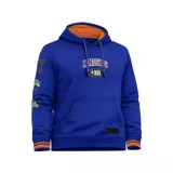 Canguro azul de los New York Knicks con capucha forrada en naranja, bolsillo tipo canguro, cordones ajustables y detalles estampados y parches alusivos al equipo en el pecho y las mangas.