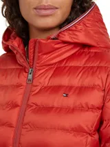 Campera acolchada Tommy Hilfiger color rojo, con capucha y cierre frontal. Tiene dos bolsillos laterales con cierre y logo bordado en el pecho.