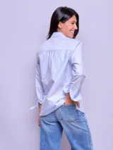 Camisa de vestir entallada a rayas verticales celestes y blancas, de manga larga y cuello clásico.