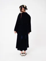 Kimono largo de terciopelo negro, con mangas largas y diseño abierto. Confeccionado en una mezcla de viscosa y poliamida, ofrece una caída fluida y elegante.