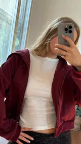 Campera de jogging bordó con cierre frontal completo, capucha y bolsillos laterales. Confeccionada en tela frizada en su interior, ofrece un ajuste cómodo y cálido.