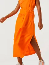 Pollera midi color naranja con lazo en la cintura y abertura lateral.