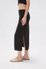 Falda midi de corte tubo confeccionada en modal, con detalle de frunces laterales que aportan movimiento y ajuste al cuerpo.