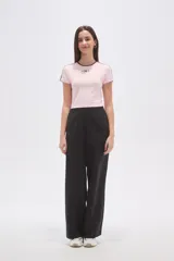 Remera cropped de color rosado con cuello redondo y detalles de costuras en color marrón. Presenta un bordado frontal con el número 94 y estrellas.