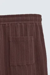Bermuda de corte relajado color marrón oscuro, confeccionada en tejido jacquard con textura acanalada vertical. Presenta cintura elástica ajustable con cordón, bolsillos delanteros y un bolsillo trasero de plastrón.