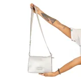 Cartera bandolera Korium Talia color gris claro, con correa larga regulable y logo metálico en el frente.