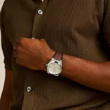 Reloj Fossil modelo Everett con caja plateada de acero inoxidable de 42mm y correa de cuero marrón de 18mm. Esfera color champán con textura, agujas plateadas y fechador a las 6. Resistente al agua hasta 50 metros.
