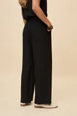 Pantalón gris de corte amplio y silueta fluida, con cintura elástica y cordón ajustable.