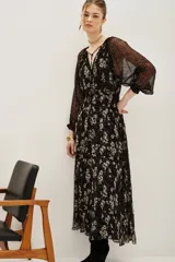 Vestido midi de viscosa con estampado floral y de lunares, cuello en V con lazo ajustable, mangas largas abullonadas con puños elásticos y falda fluida con forro interior.