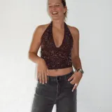 Top marrón con lentejuelas plateadas, escote halter y espalda descubierta.