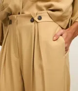 Pantalón recto de tiro alto confeccionado en viscosa, con cintura clochard y detalle de botones frontales. Presenta un diseño fluido y minimalista.