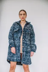 Tapado 3/4 de paño tejido en calidad italiana, color azul marino y blanco con textura bouclé, cuello camisero, cierre frontal de botones y bolsillos con solapa en el pecho.
