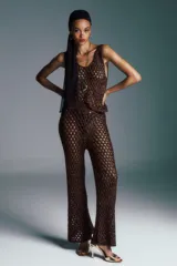 Pantalón largo acampanado color café, de punto calado con cintura elástica.