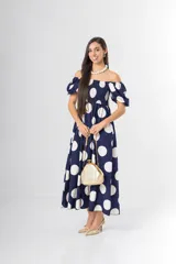 Vestido midi azul marino con estampado de lunares blancos, escote off-shoulder con mangas abullonadas y cuerpo elástico tipo smock.
