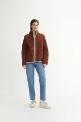 Campera color crema de sherpa doble faz combinada con nylon de alta calidad. Detalle de vivos en nylon con bolsillos cuadrados aplicados.