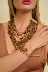 Conjunto de collar y pulsera multitiras confeccionados con cuentas de piedra ojo de tigre y abalorios dorados sobre base tejida en hilo color tostado.