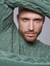 Sweater verde de tejido de punto con trenzas.