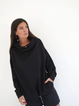 Buzo negro oversize de felpa con capucha y espalda descubierta, mangas largas, calce relajado y detalle de logo bordado en la parte inferior.