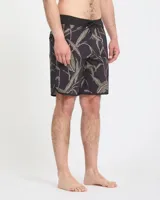 Short de baño Volcom modelo Abg Encounter Scallop Mod de 19 pulgadas, color negro con estampado de hojas y ramas en tonos verdes y rosados, con cintura ajustable mediante cordón.