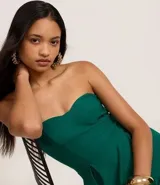 Vestido corto strapless color verde esmeralda, con escote corazón y falda acampanada con pliegues.