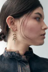 Aros colgantes dorados con forma de flecha con detalles de puntas.