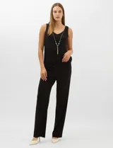 Conjunto de tres piezas compuesto por una musculosa negra con escote en V, un pantalón palazzo de tejido de punto liso con cintura elástica y una túnica larga de tul negro con mangas 3/4. La túnica presenta un bordado floral detallado con aplicaciones de lentejuelas.