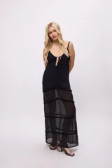 Vestido midi de tela semitransparente con acabado brillante en color verde esmeralda. Presenta un diseño con volados en los recortes, escote con cordón ajustable y breteles finos.