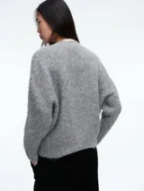 Sweater de tejido de punto con textura suave y acabado ligeramente afelpado, de corte holgado, cuello redondo y mangas largas.