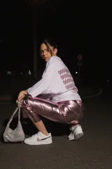 Pantalón de ecocuero con acabado metalizado en color rosado, de corte capri semi oxford y tiro medio-alto. Presenta cierre frontal con botón metálico y bolsillos traseros.