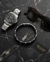 Pulsera de eslabones combinados en acero inoxidable y cerámica negra, con diseño moderno y cierre oculto.