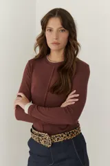 Remera color beige de mangas largas con cuello redondo y puños blancos en contraste.