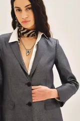 Saco de corte sastre con acabado metalizado, de calce recto y estructura clásica con solapas.