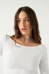 Top blanco de manga larga con cuello bote y corte crop.