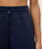 Pantalón deportivo de corte recto confeccionado en una mezcla de poliéster, modal y elastano. Presenta cintura elástica con cordón ajustable y detalle en rib, ofreciendo un calce cómodo y versátil.