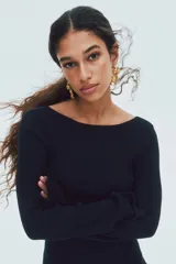 Vestido corto de punto acanalado con escote bote, mangas largas y falda acampanada con vuelo. Presenta un diseño ajustado en el torso y espalda descubierta en U.