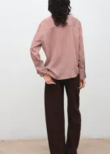 Camisa de corte recto con diseño de rayas verticales en tonos terracota y blanco. Presenta cuello camisero clásico, cierre frontal con botones y mangas largas con puños abotonados.