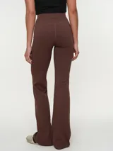 Calza larga flare de cintura alta, color gris oscuro, con diseño ajustado en las piernas y botamanga amplia.