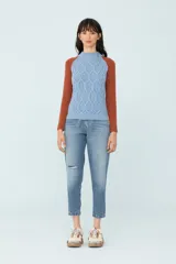 Sweater bicolor de tejido de punto, con mangas ranglán color ladrillo y cuerpo celeste con diseño de trenzas.