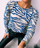 Remera de manga larga con cuello redondo y estampado de cebra en colores verde, rojo, azul y marrón.