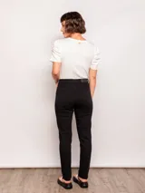 Pantalón chupín negro de tiro alto con bolsillos frontales y traseros.