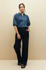 Pantalón de jean azul oscuro de corte recto y tiro alto, con costuras a la vista.